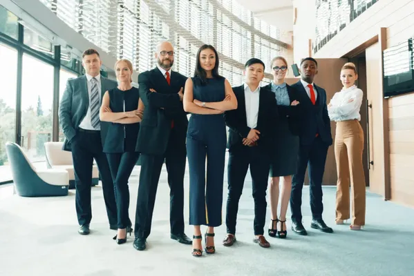 Un equipo de trabajo diverso y profesional posa, mostrando los resultados de un coach empresarial.