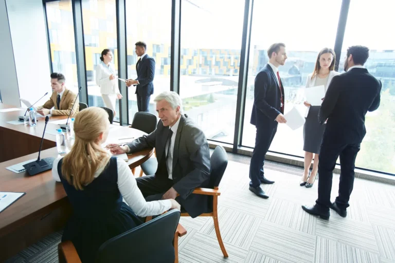 Grupos de empresarios conversando en una oficina moderna, buscando ideas sobre cómo hacer crecer mi negocio.
